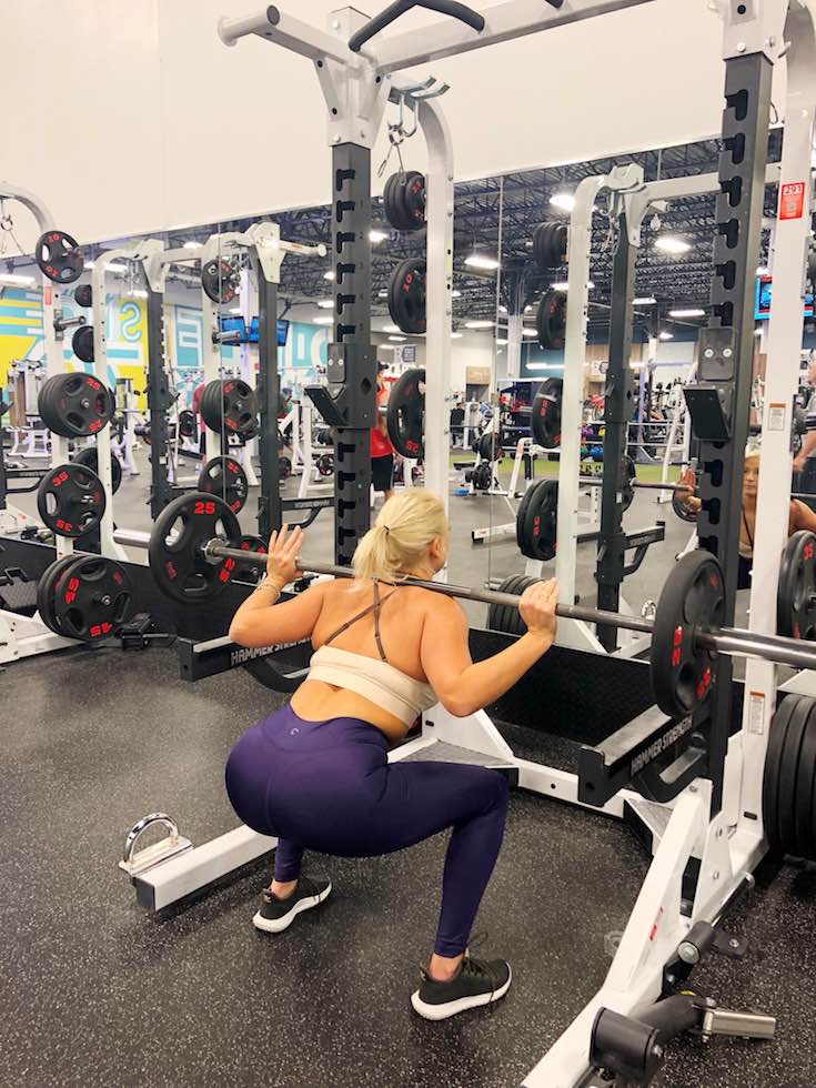 Exercise plan, Beige brown sportsbra top and purple yoga pants, woman squatting